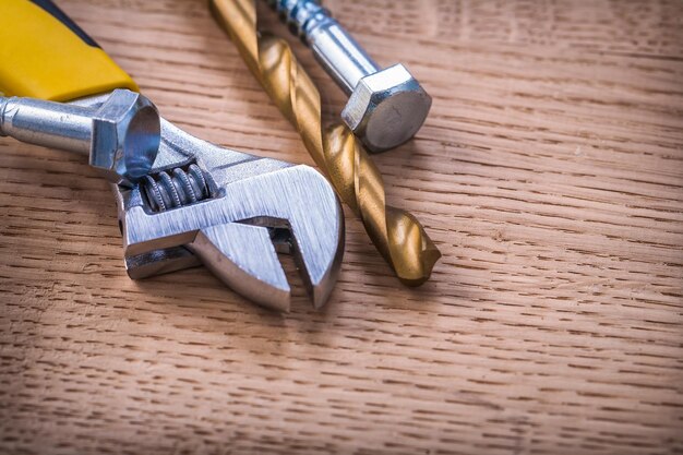 Drill bolts and wrench on wooden board