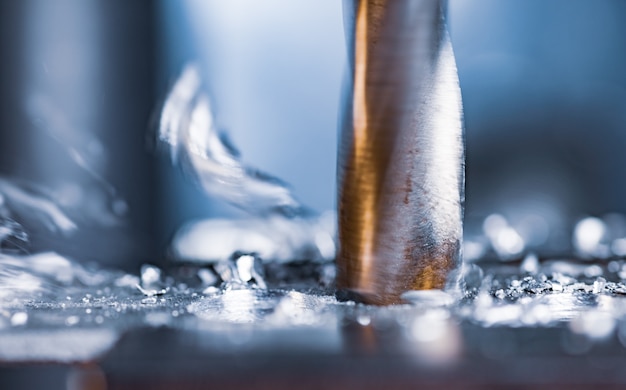 Processo di perforazione con il primo piano dei trucioli sul posto di lavoro in officina