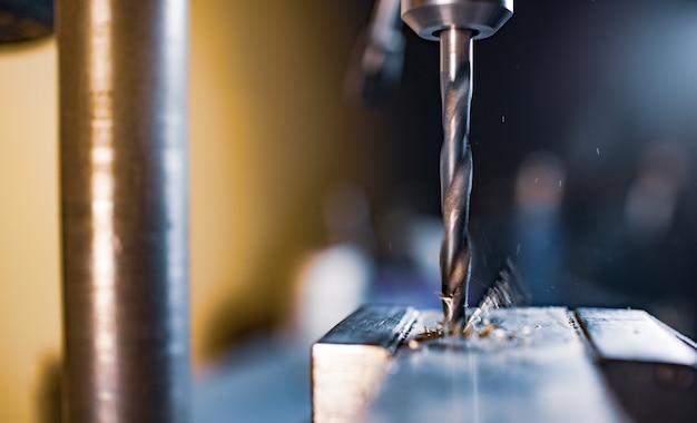 Drilling process with shavings close-up at the workplace in workshop