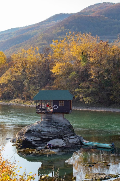 Photo drina river house wooden cabinlike house on the rock in the middle of the drina river near the