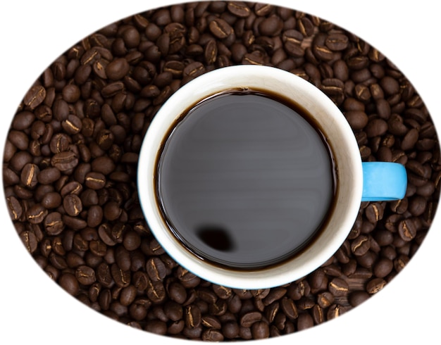 Фото Выпейте чашку кофе в синей чашке и кофейных зернах, изолированных на белом, с вырезкой сверху