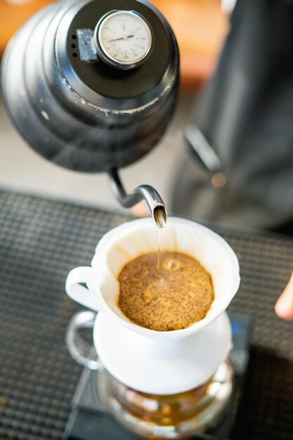 Drink coffee pot is hot morning cafe Een hand die dampende koffie in een kopje op een bureau giet als je thuis werkt