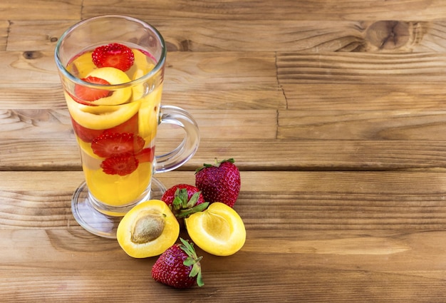 Drink from fresh apricots and strawberries in a glass.