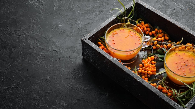 Drink from sea buckthorn berries Winter hot drink Fresh sea buckthorn on a twig Top view Free space for your text