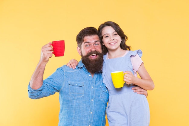 Drink healthy live well Happy family drink milk tea Little child and father hold cups of hot drink Drinking natural healthy beverage Enjoying delicious drink recipe Morning and breakfast