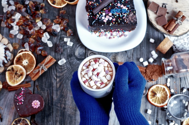 Drink met marshmallow in zijn handen over een tafel met snoep