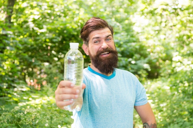 Drink Plenty Of Water drinking water in forest outdoor with sunset nature on background Bearded man with water bottle fitness portrait of bearded man happy mature guy thirsty hipster traveler