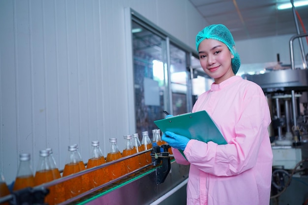 Drink production employee works at food and beverage\
manufacturing quality check ing production line