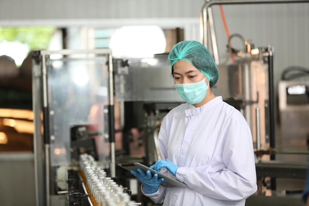 Drink production employee works at food and beverage\
manufacturing quality check ing production line