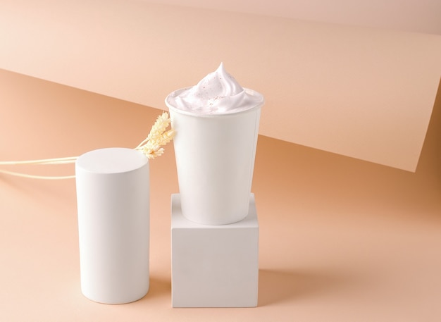 Drink with cream in a glass on a cube platform