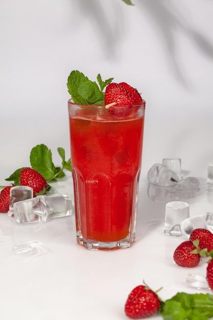 Drink with fresh strawberries and passion fruit in glass with ice and fresh mint