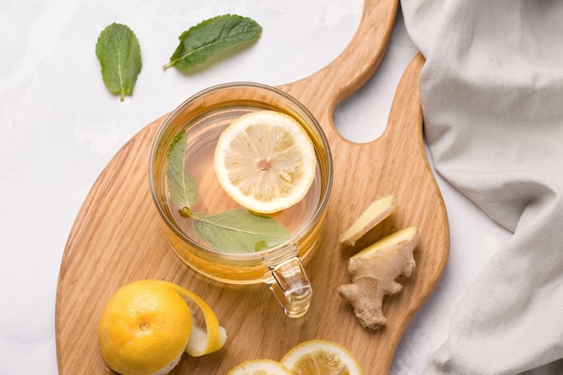 Drink with lemon, ginger and mint on a wooden chopping board