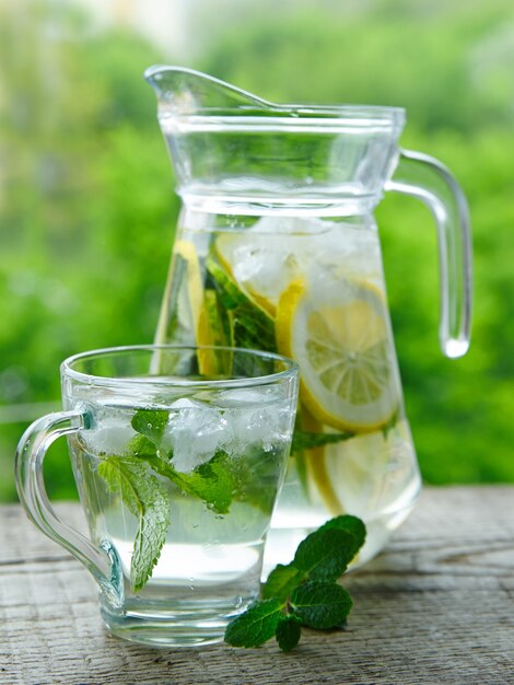 Drink with lemon and mint in a glass jug