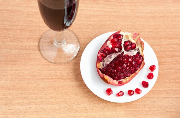 Drinkbeker wijn en een granaatappel op de tafel