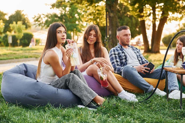 Drinken en roken Groep jongeren vieren zomerdag in het park