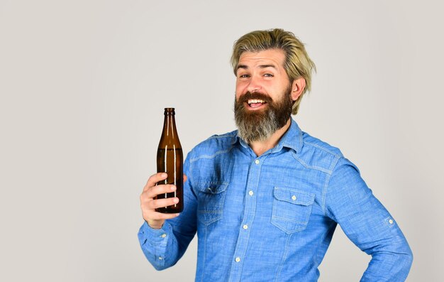 Drinking beer good for your mood Making Homemade Kombucha Refreshing lemonade Soda drink Hipster at bar Man beard and mustache hold bottle Alcohol drink Sparkling water drink Cold beverage