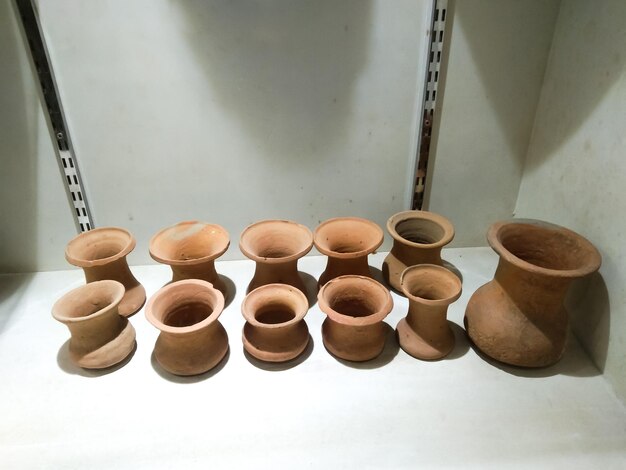 Drinking earthenware jug on stone shelf indoors.