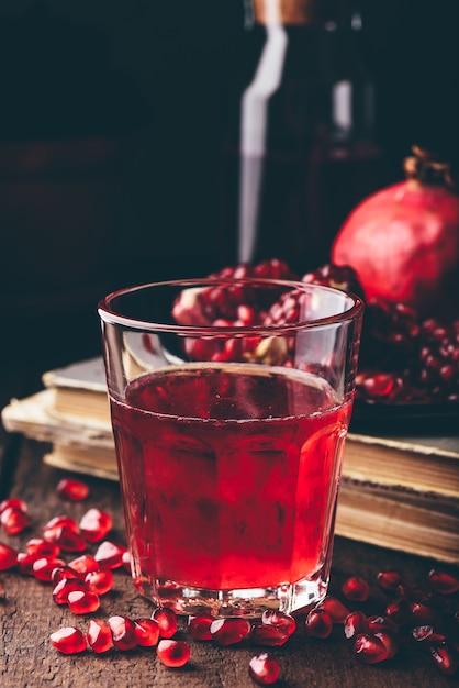 Drinking glass with pomegranate cocktail on wooden table