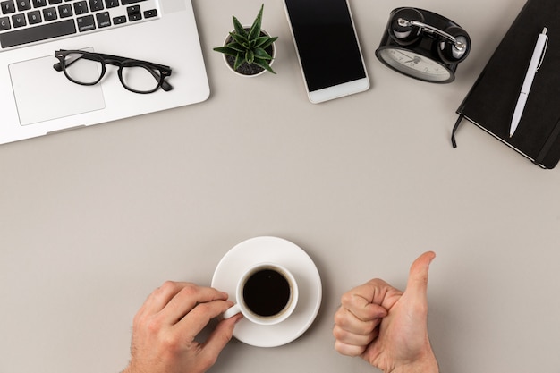 写真 オフィスの机の上の仕事でおいしいコーヒーを飲む