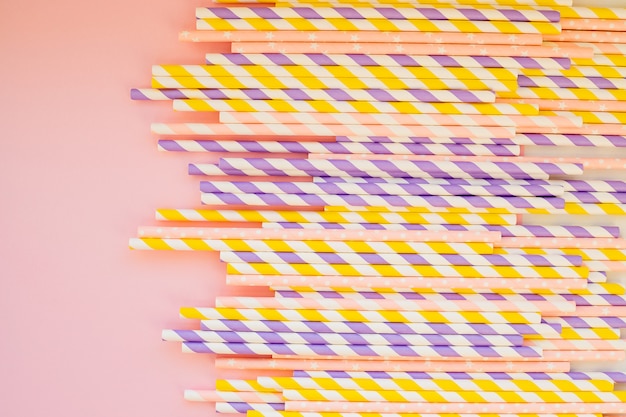 Drinking paper colorful straws for summer cocktails on light pastel wall with copy space. Eco friendly Reusable Straws. Paper cocktail tubes. Kraft paper straw for drinking coffee or tea