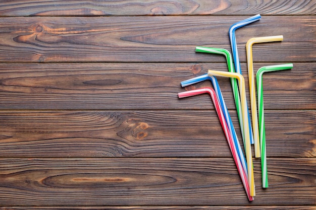 Drinking straws for party on Colored background Top view of colorful plastic disposable straws for summer cocktails different straws for juice with copy space