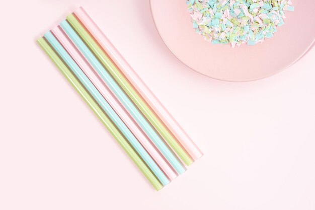 Drinking straws and plate full of microplastics on a pink background Impact of micro plastic on the food chain The idea of micro plastic pollution Concept of environmental damage