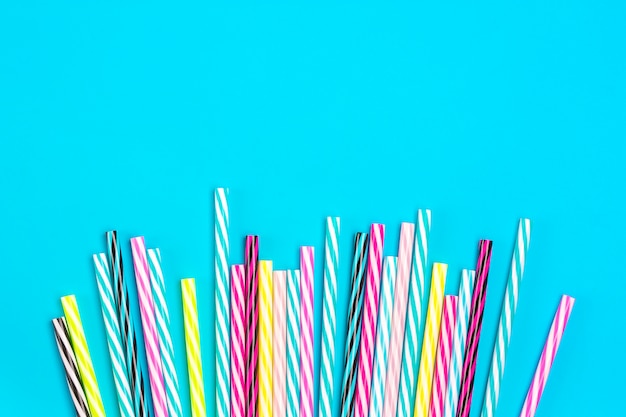 Photo drinking straws with stripes for party  on blue background