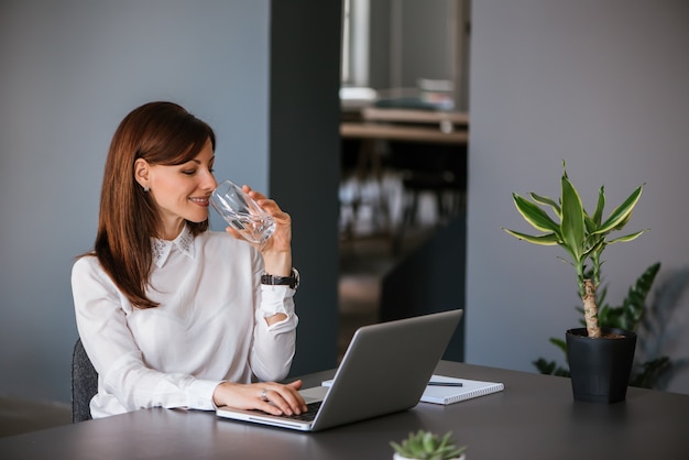 Drinking water while working with laptop computer