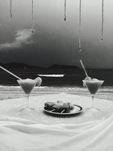 Photo drinks and food served on table at beach