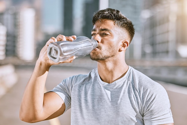 Drinkwater fitte en gezonde man die een actieve gezondheid leeft, wellness en een levensstijl die naar lichaam of gewicht kijkt Atletische hardloopfitness en sportliefhebber die koel blijft na een training of trainingsroutine