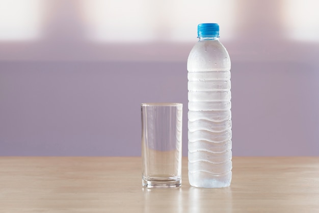 Drinkwater in plastic fles met glas op tafel