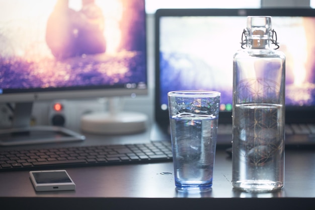 Drinkwater op kantoor close-up van glazen fles werkplek
