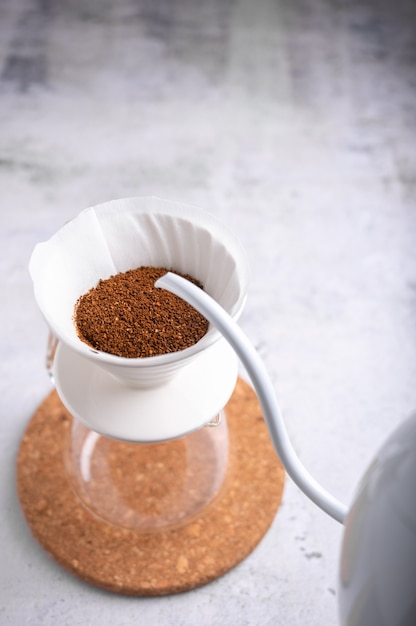 Drip brewing, filtered coffee or pour-over is a way of making coffee. Barista preparing drip on coffee ground coffee beans contained in a filter paper.