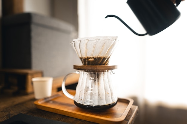 Drip coffee, barista pouring water on coffee ground with filter,brewing coffee