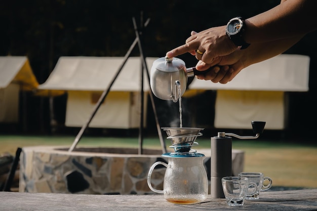 Uomo del caffè gocciolante che versa acqua calda