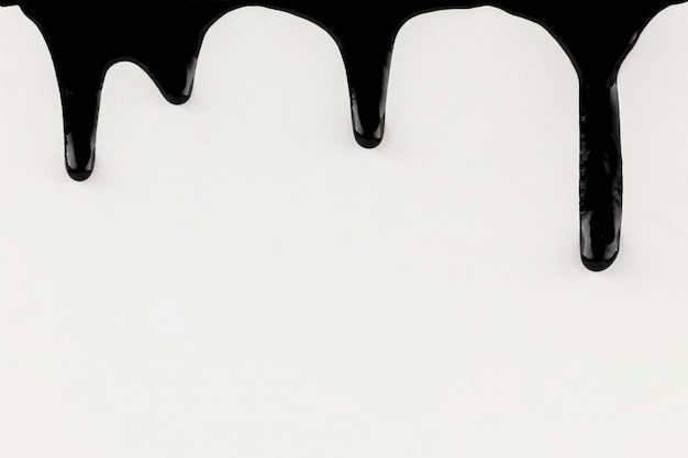 Photo dripping black paint on white background