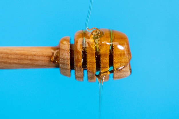 Dripping honey close-up from a wooden bucket with copy space