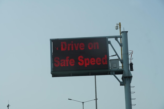 Drive on safe speed written on traffic signal on road