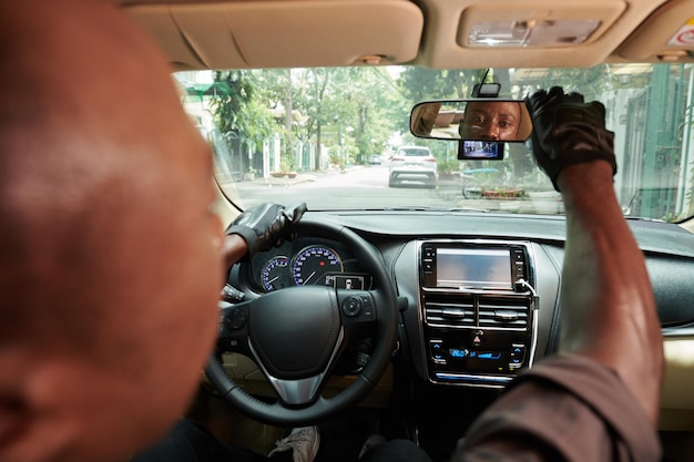 driver adjusting rear view mirror