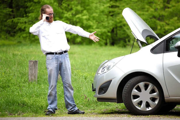 Foto autista furioso con il cellulare un'auto rotta lungo la strada