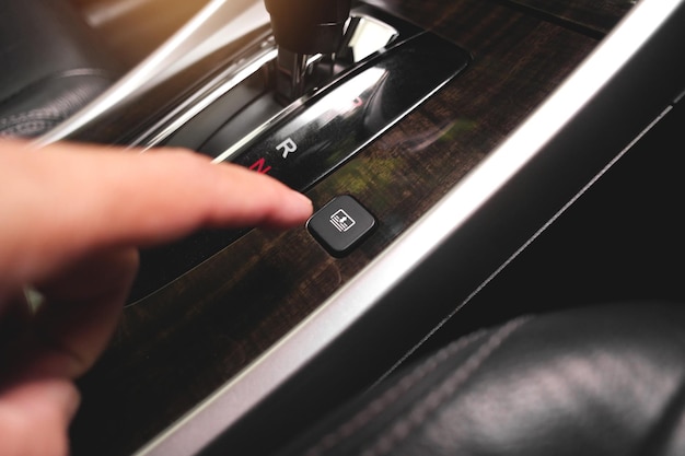 The driver hand presses the rear sunshade button switch of car.