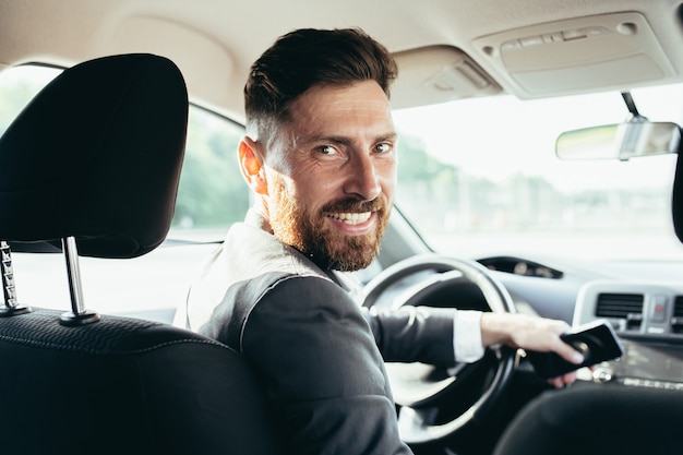 Photo the driver of a man in a business suit looks at the camera