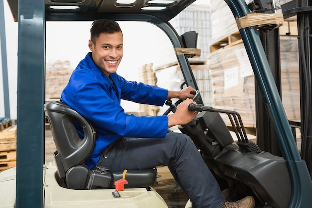 Driver operating forklift machine in warehouse