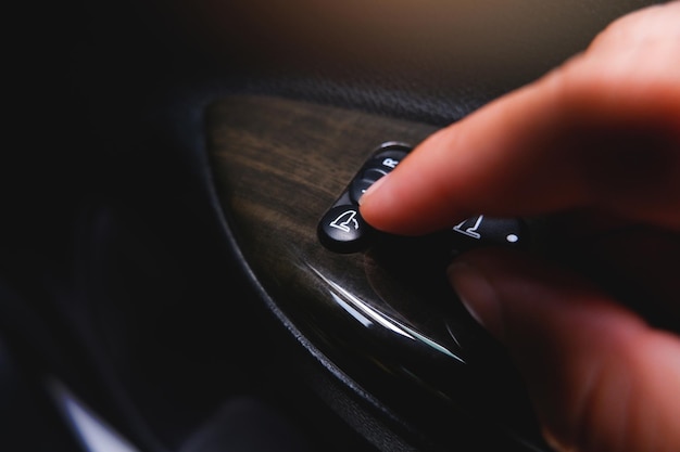 The driver presses the power folding mirror button switch with his hand