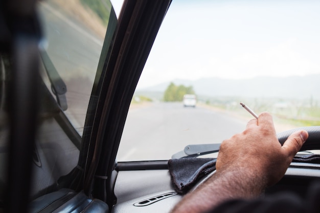 Foto conducente che fuma durante la guida