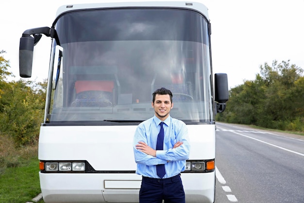 Driver standing in front of bus