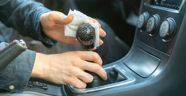 A drivers hand holding a microfibre and wipe the car interior inside