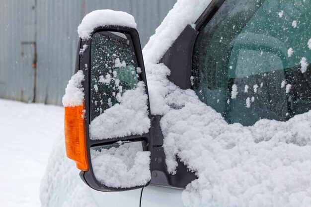 雪に覆われたトラックの運転席側ミラー