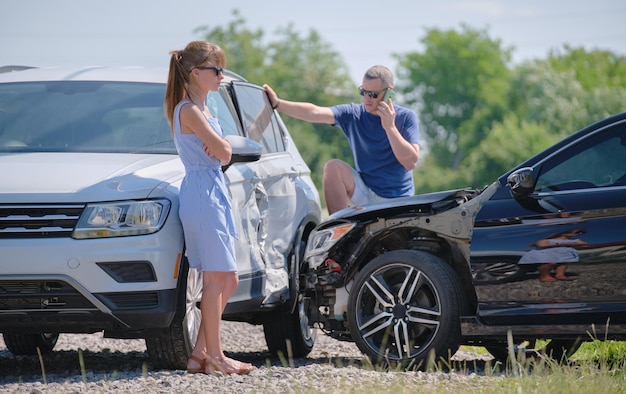 Photo drivers of smashed vehicles talking on cellphone calling for help in car crash accident on street side road safety and insurance concept