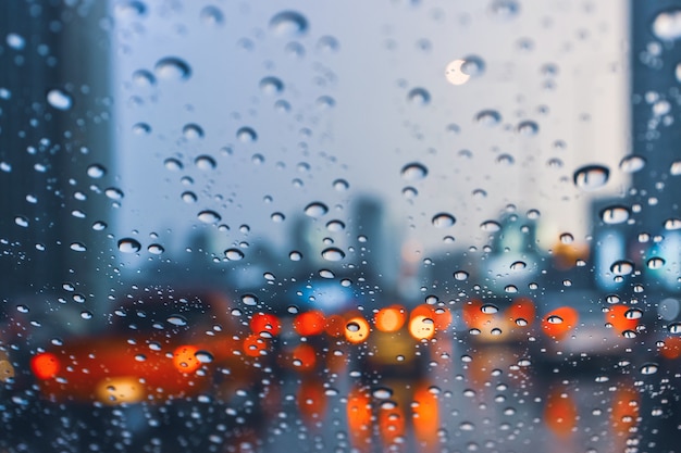 風防の上に雨滴が付いている交通渋滞で大都市の道路で車を運転